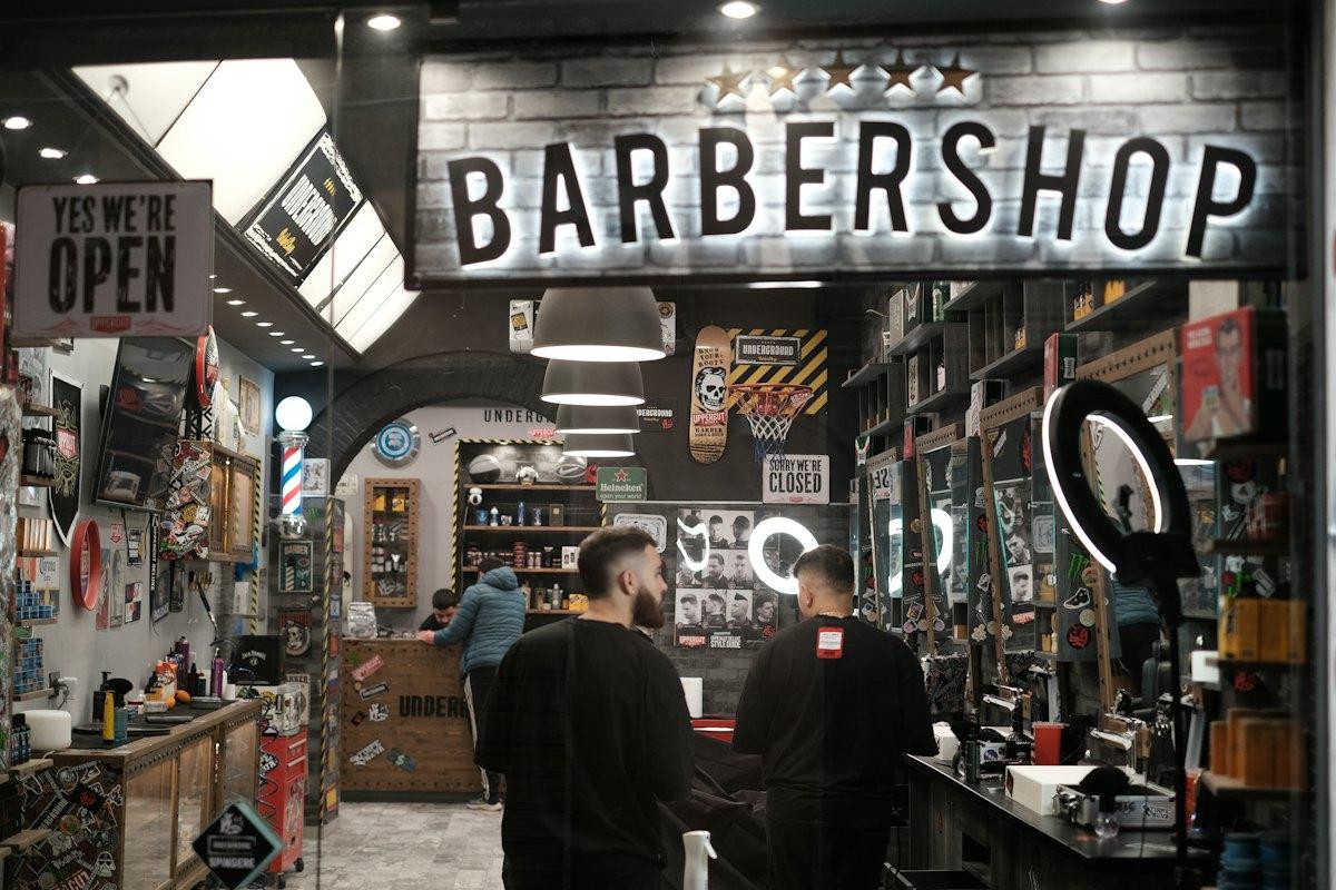 Ladenfront von Klinge & Kamm mit beleuchtetem Barbershop-Schriftzug